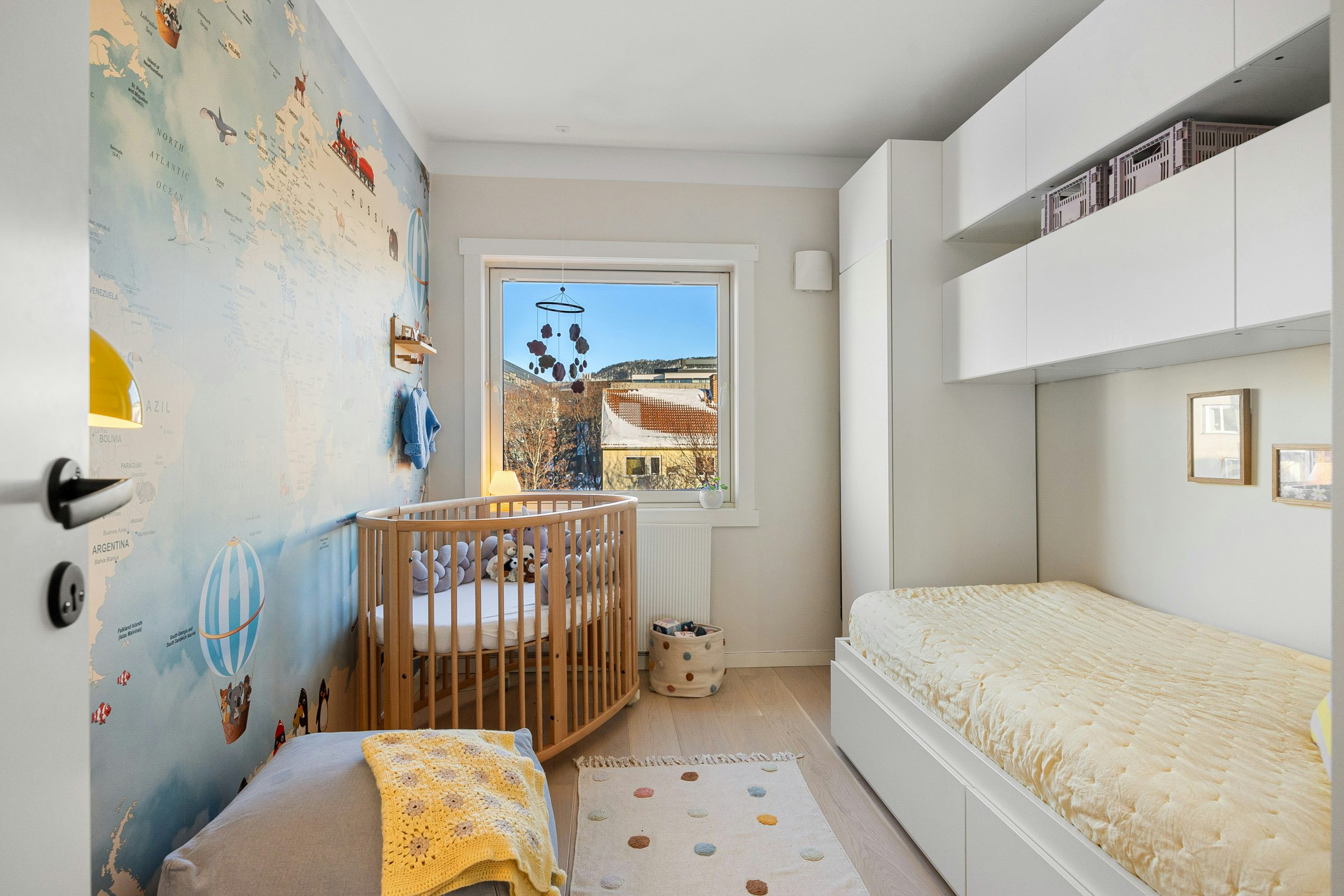 A baby's room with a crib and a window