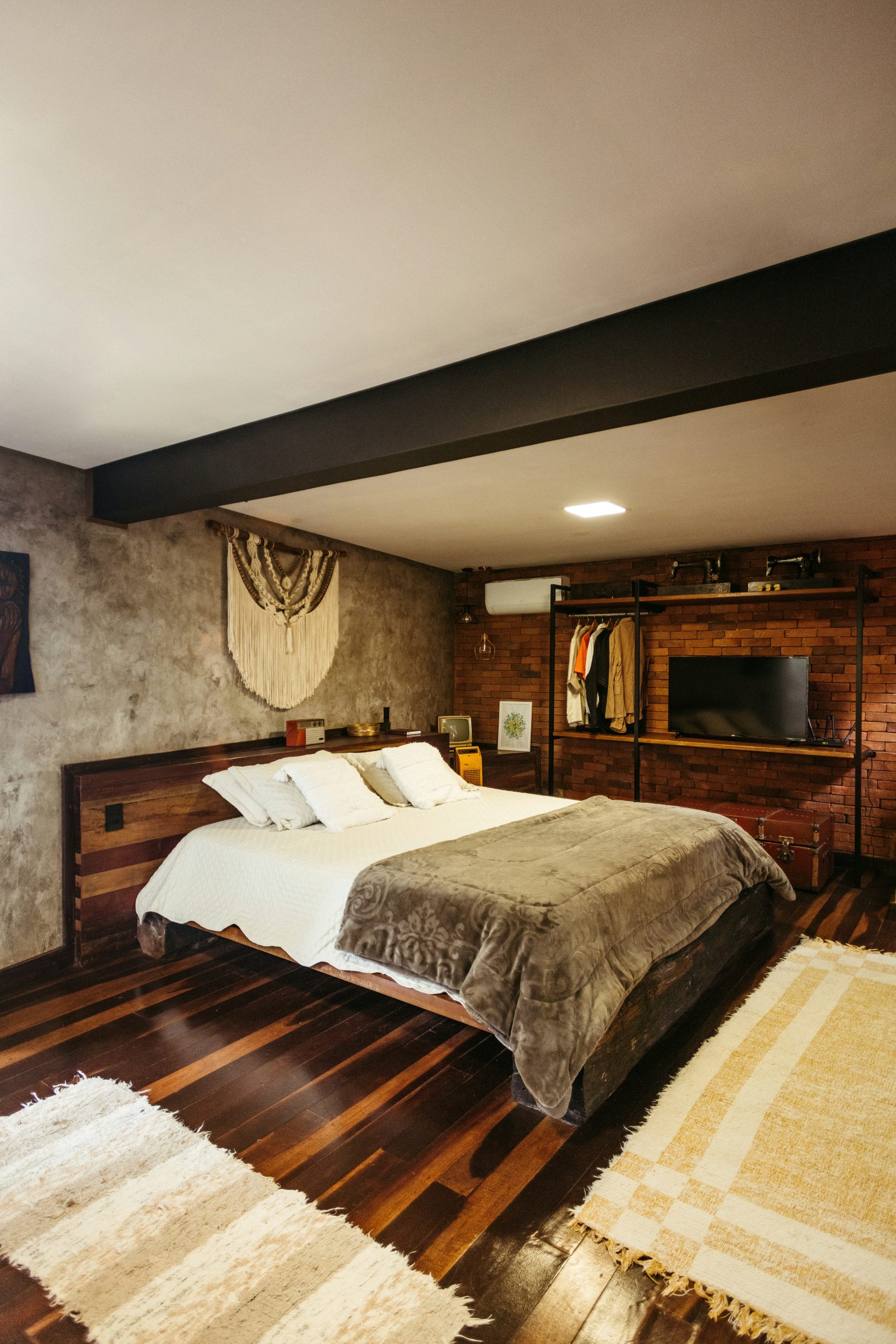 A bedroom with a bed, dresser and television