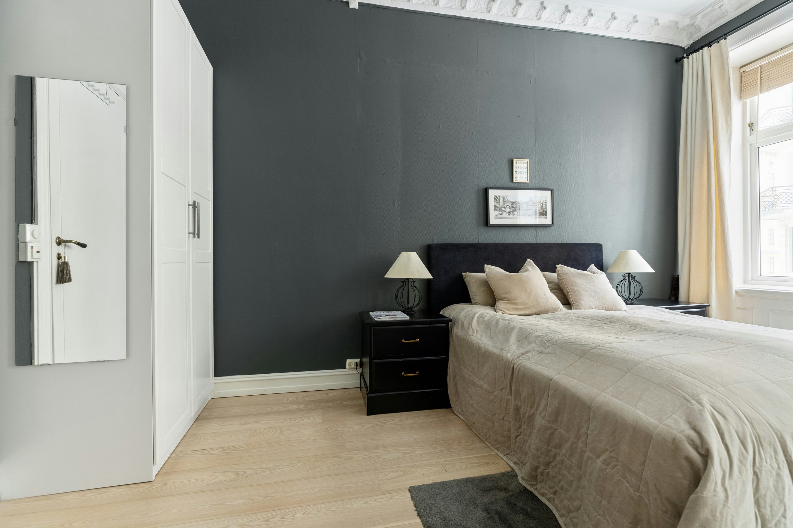 A bedroom with a bed, nightstands and a window