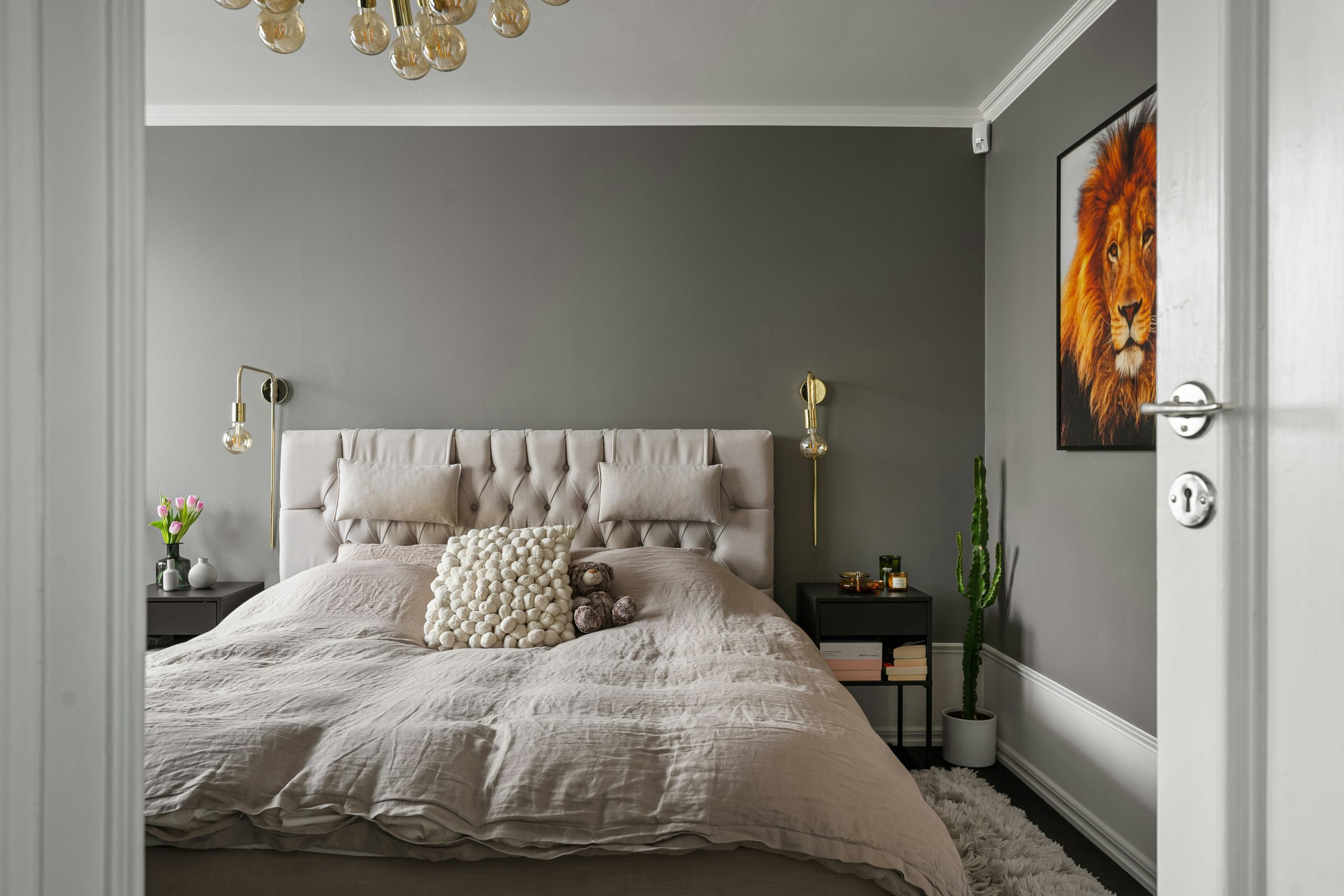 A bedroom with a large bed and a chandelier