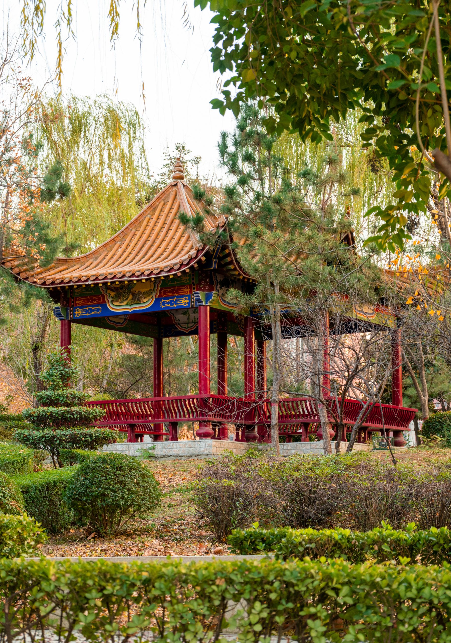 a gazebo in a park surrounded by trees and bushes