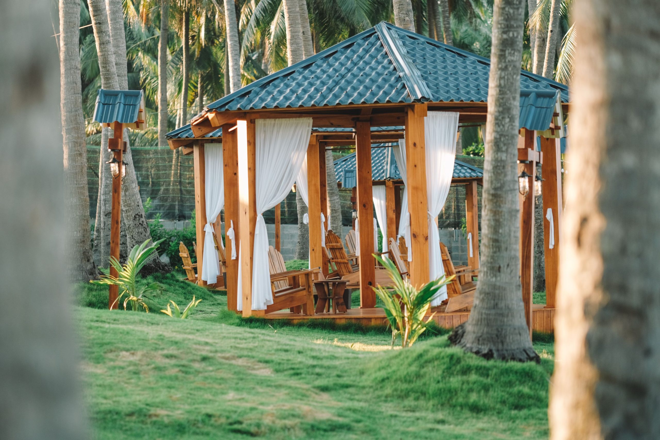 A serene wooden gazebo amidst palm trees in Phan Thiet, Vietnam, ideal for relaxation.