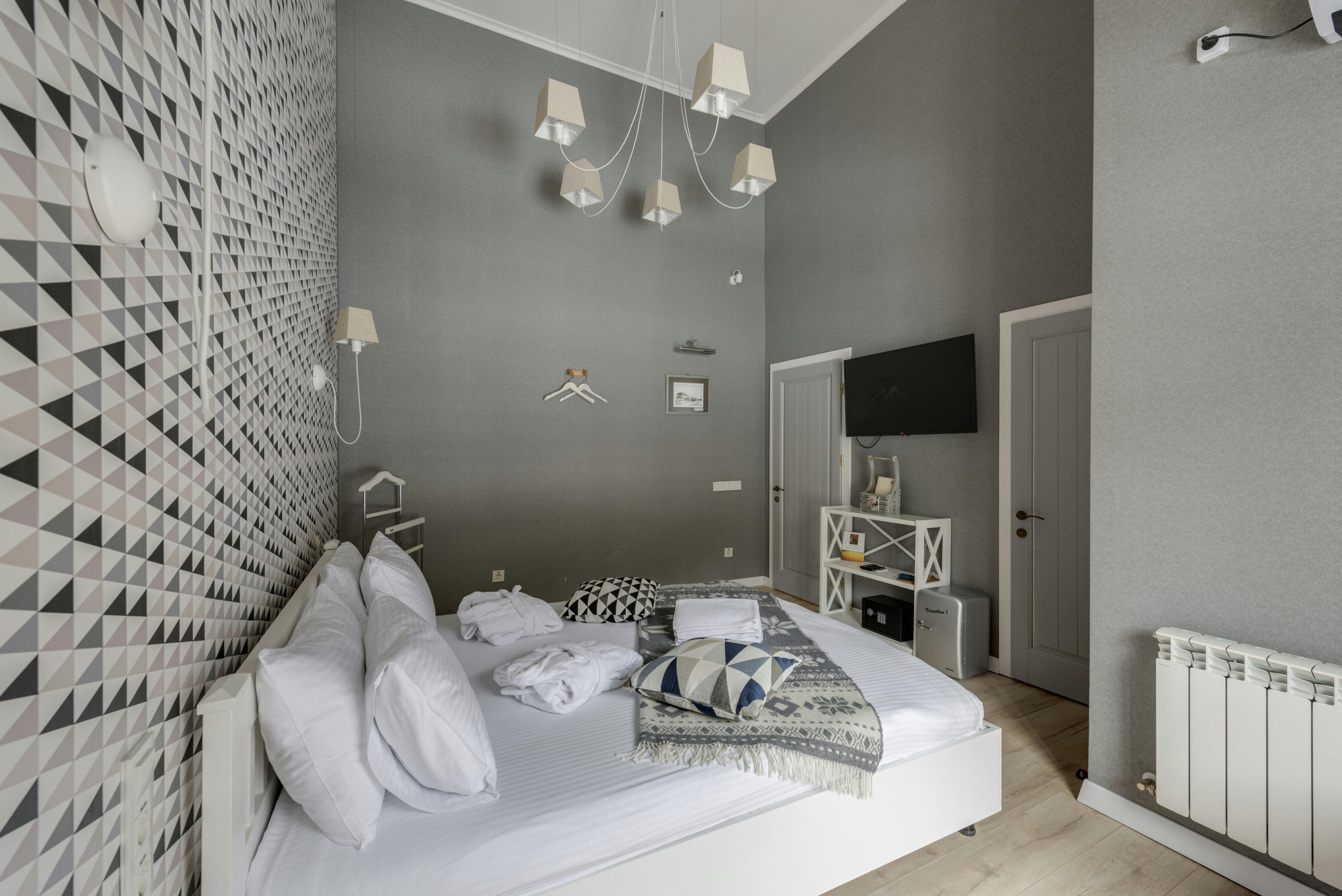 A stylish contemporary bedroom with grey walls and elegant decor, ideal for a hotel or modern home.