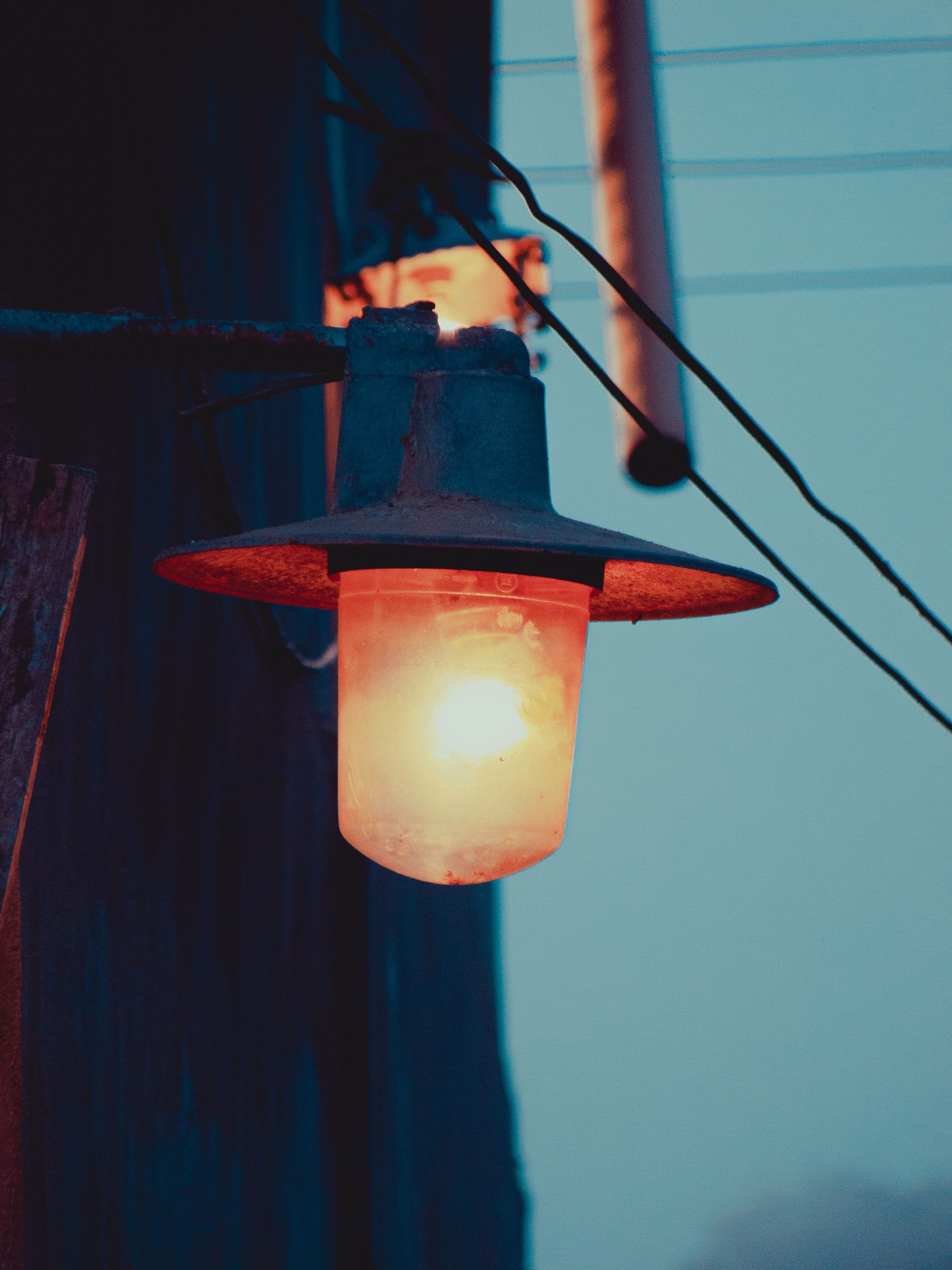An atmospheric shot of a glowing street lamp casting warm light at twilight.