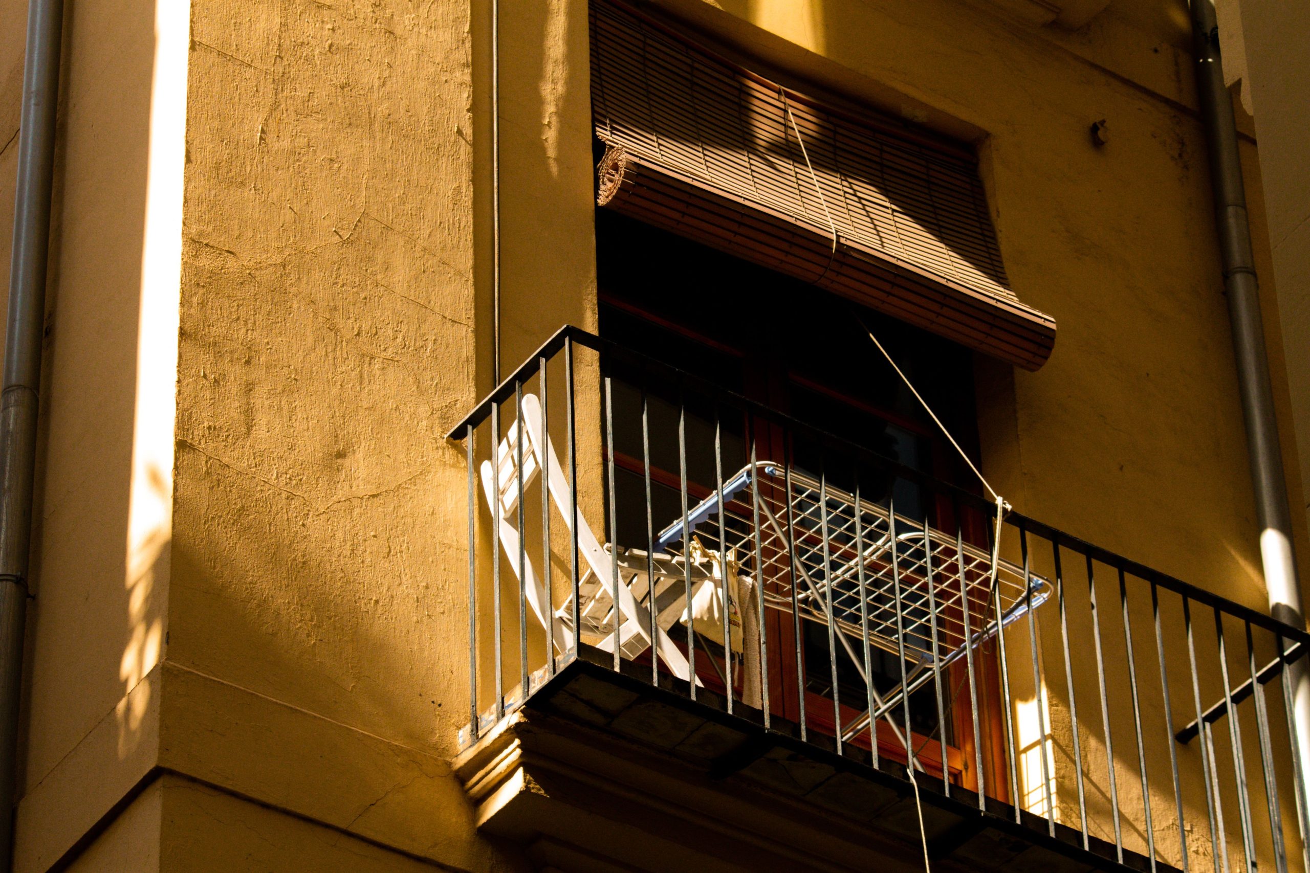 Balcony with a chair and drying rack in sunny Valencia, Spain.