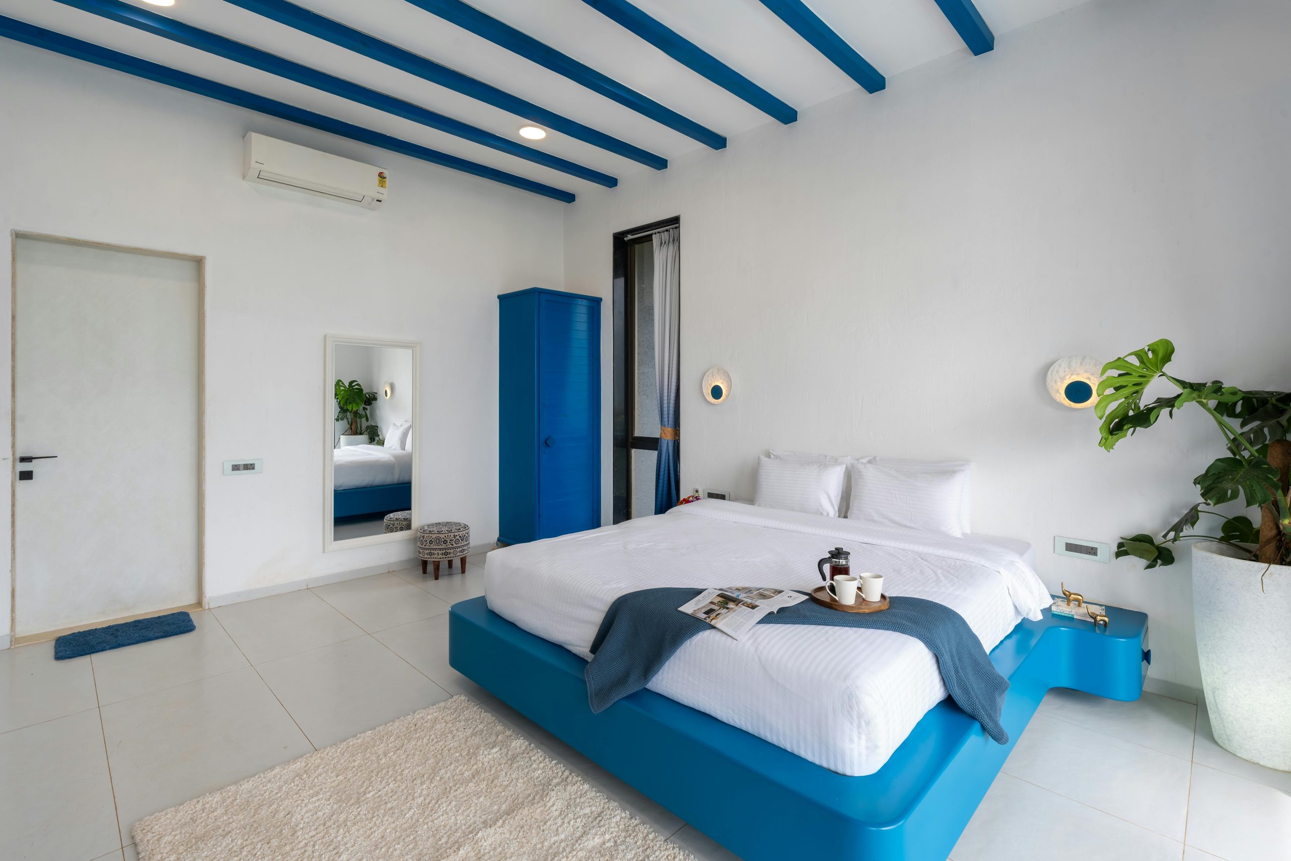 Bright and inviting modern bedroom featuring blue accents and sleek furniture design.