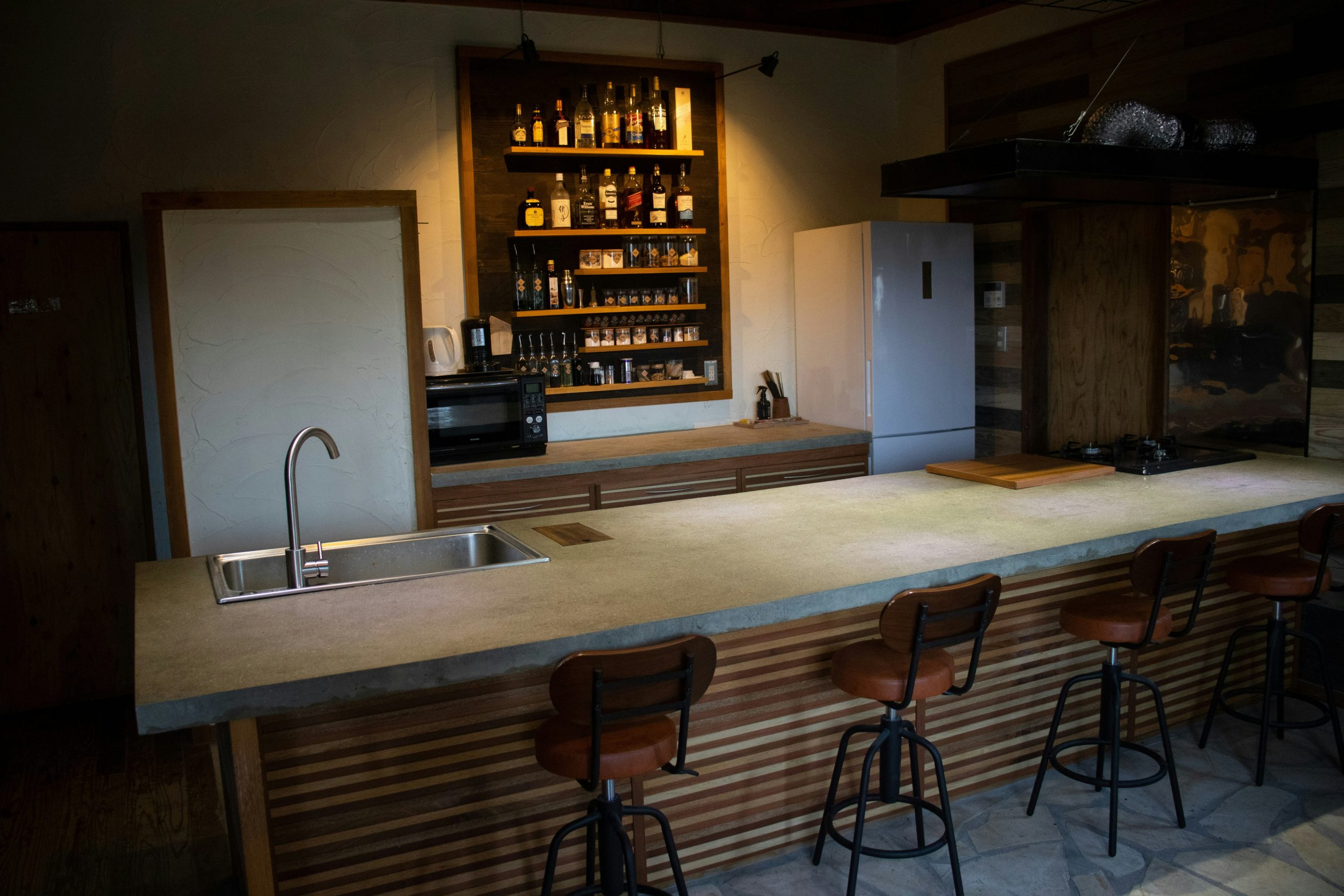 brown wooden bar stools beside counter