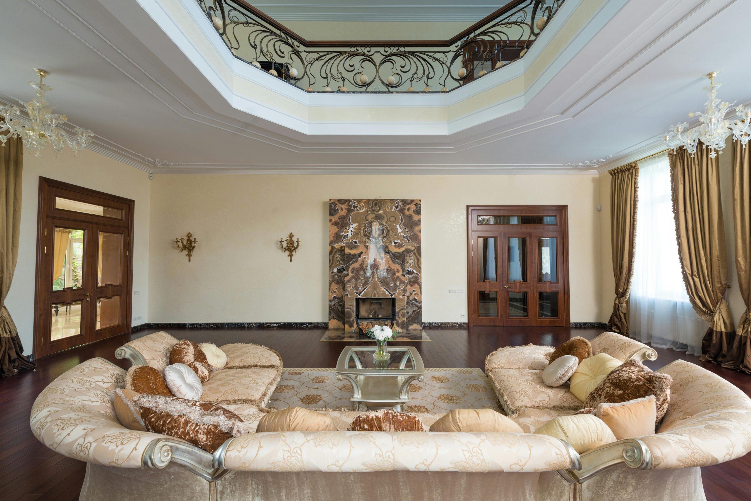 Comfortable living room with glass table arranged with blooming flowers near large cozy sofa