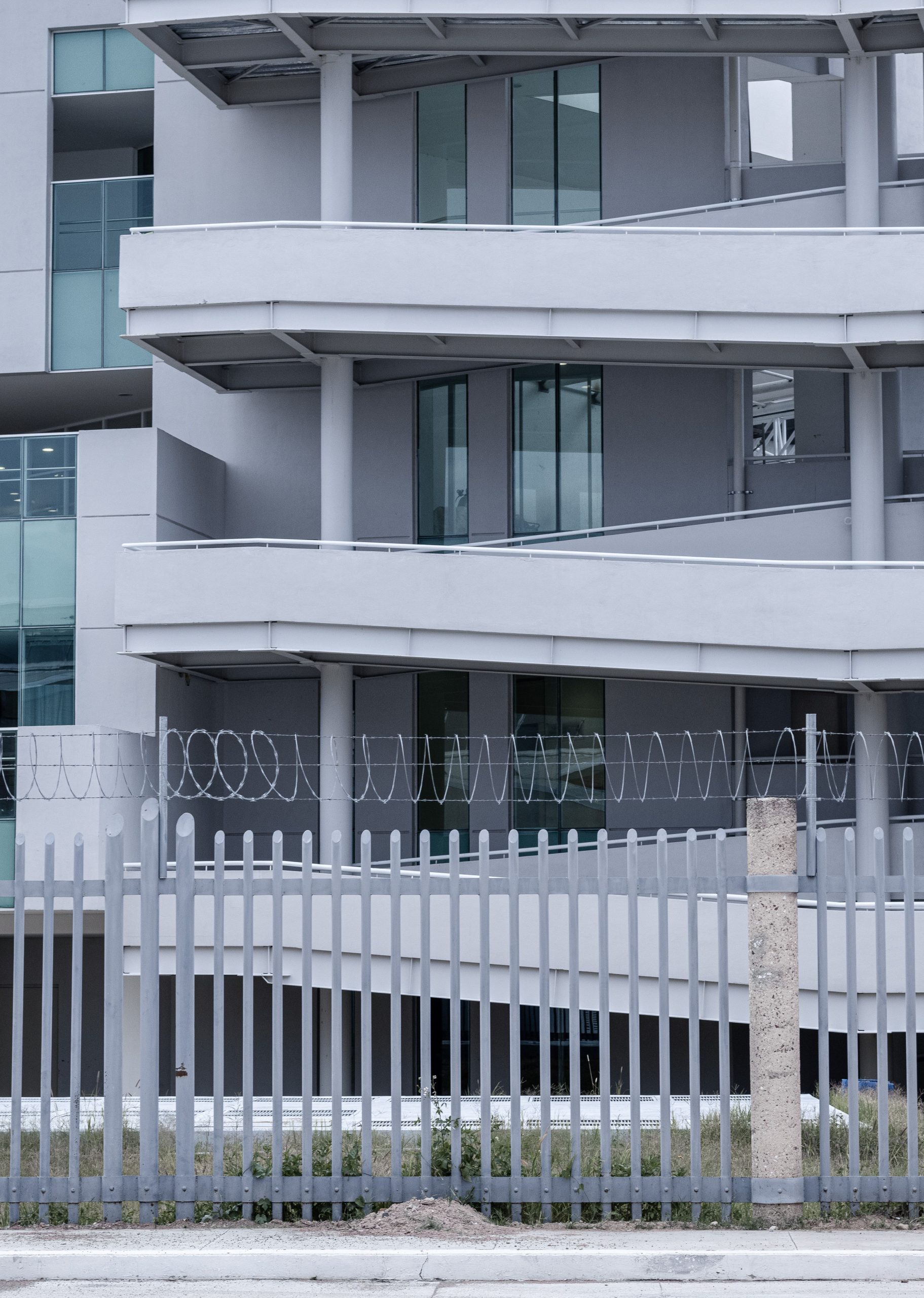 Contemporary apartment complex with a minimalist design and fenced enclosure.