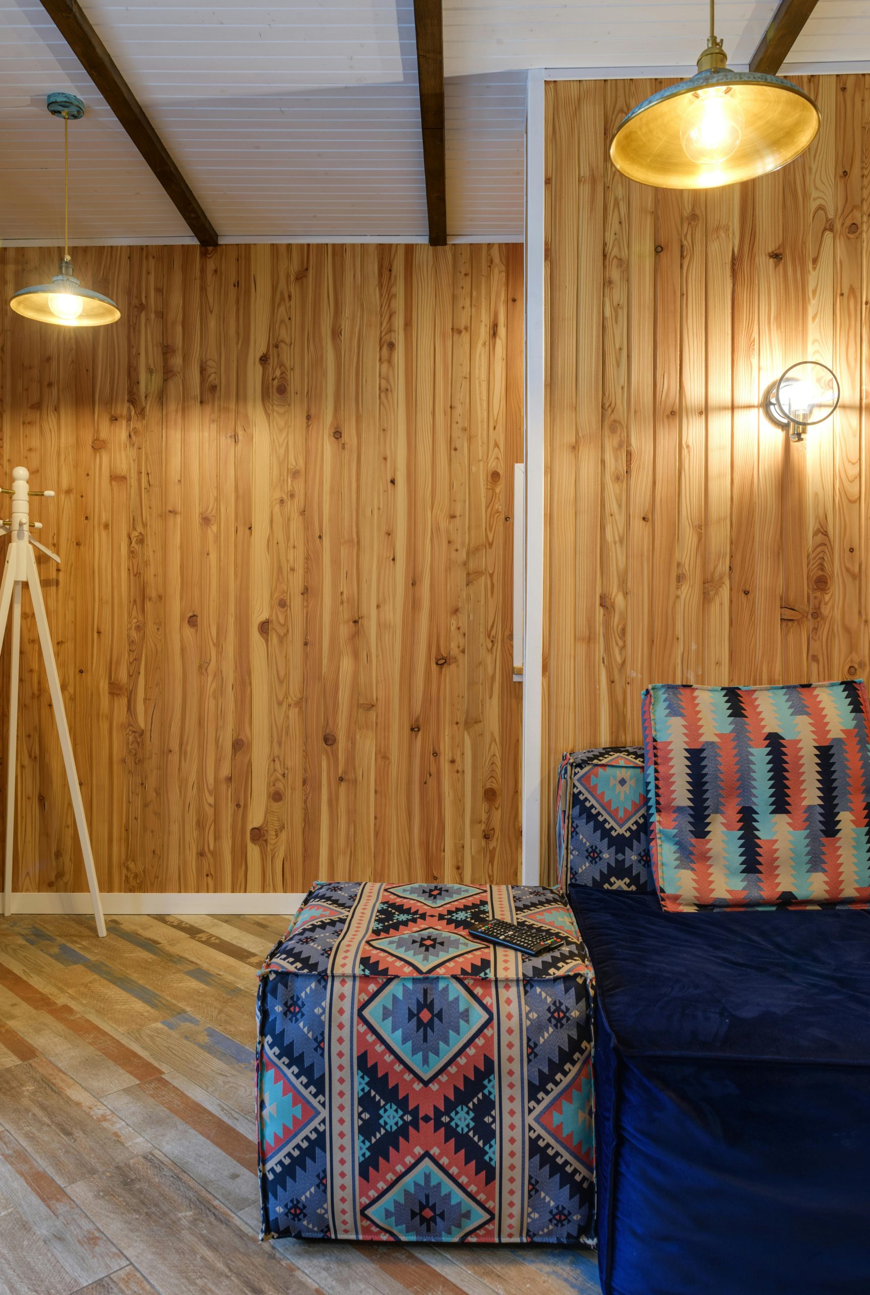 Contemporary home interior featuring a colorful patterned couch and wooden panel walls.