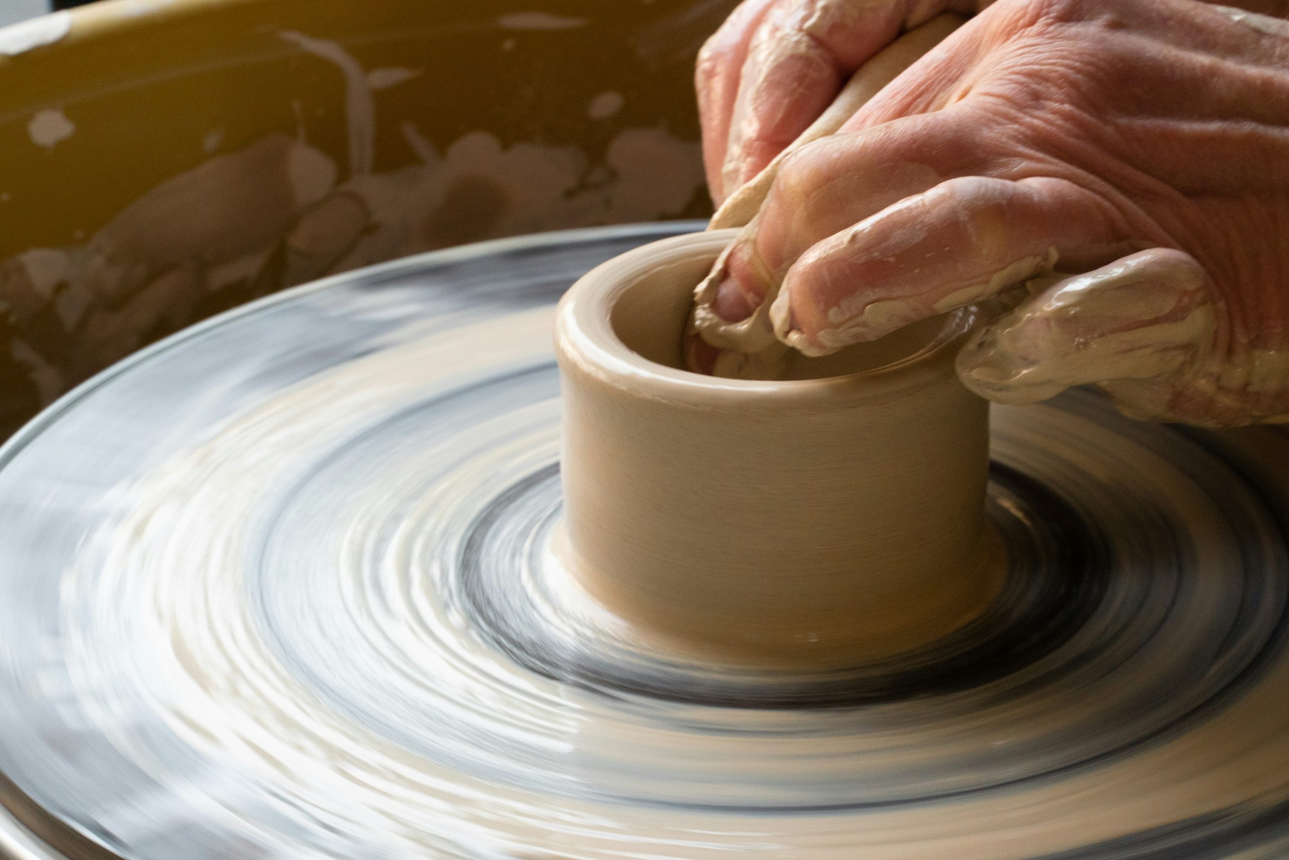 Creating cups on a potter's wheel.