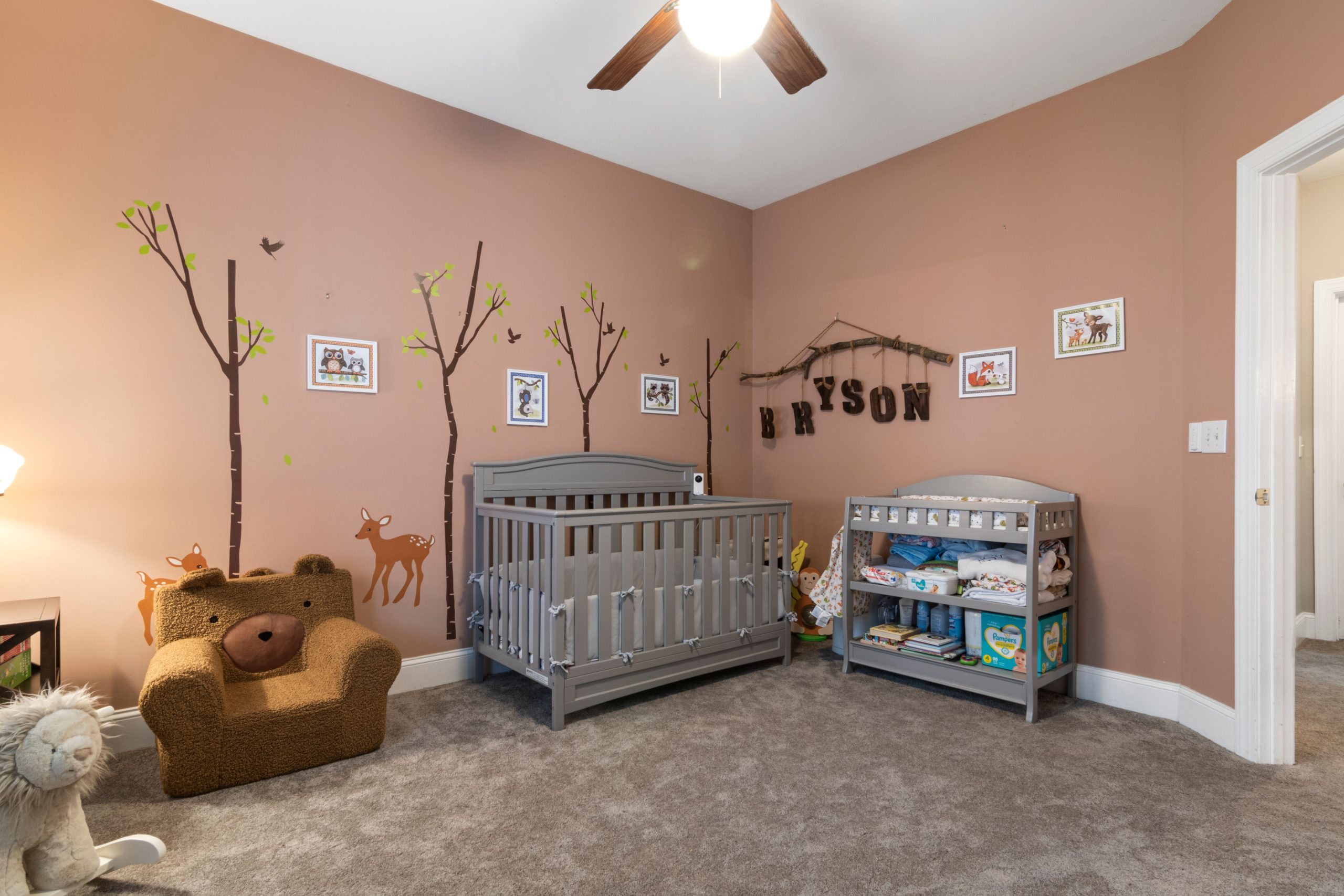 Cute nursery room interior with crib, animal-themed decor, and warm lighting.