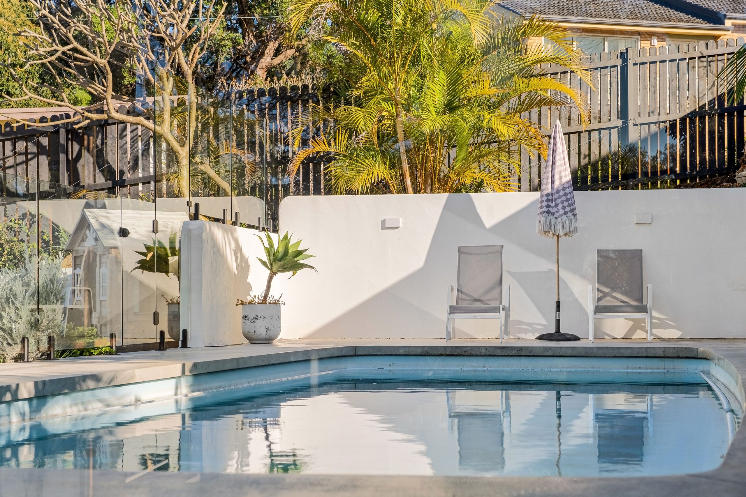 Elegant backyard pool with sun loungers, ideal for a relaxing summer.