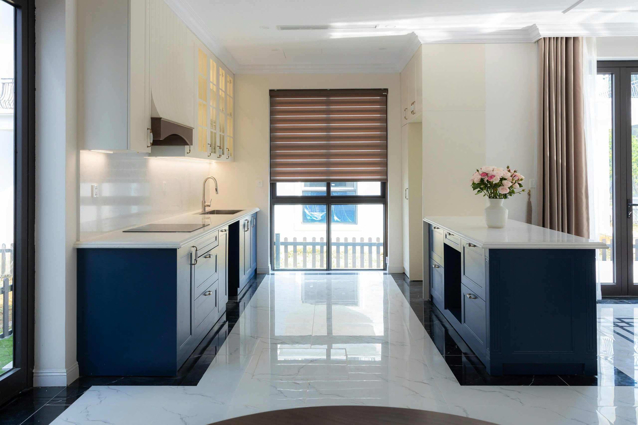 Elegant kitchen interior featuring blue cabinets and marble flooring.