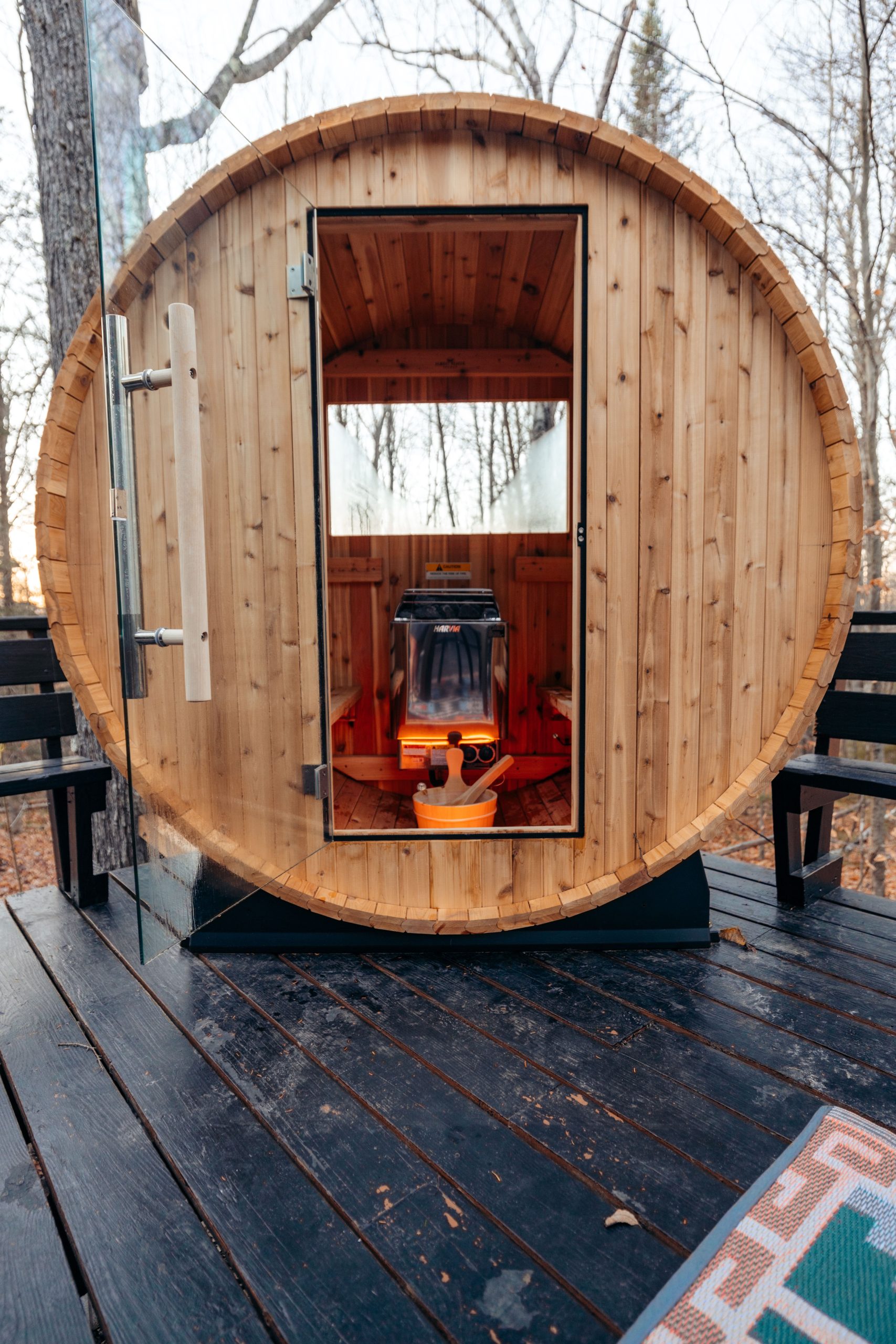 Explore a rustic wooden barrel sauna on a deck in scenic Stowe, Vermont.