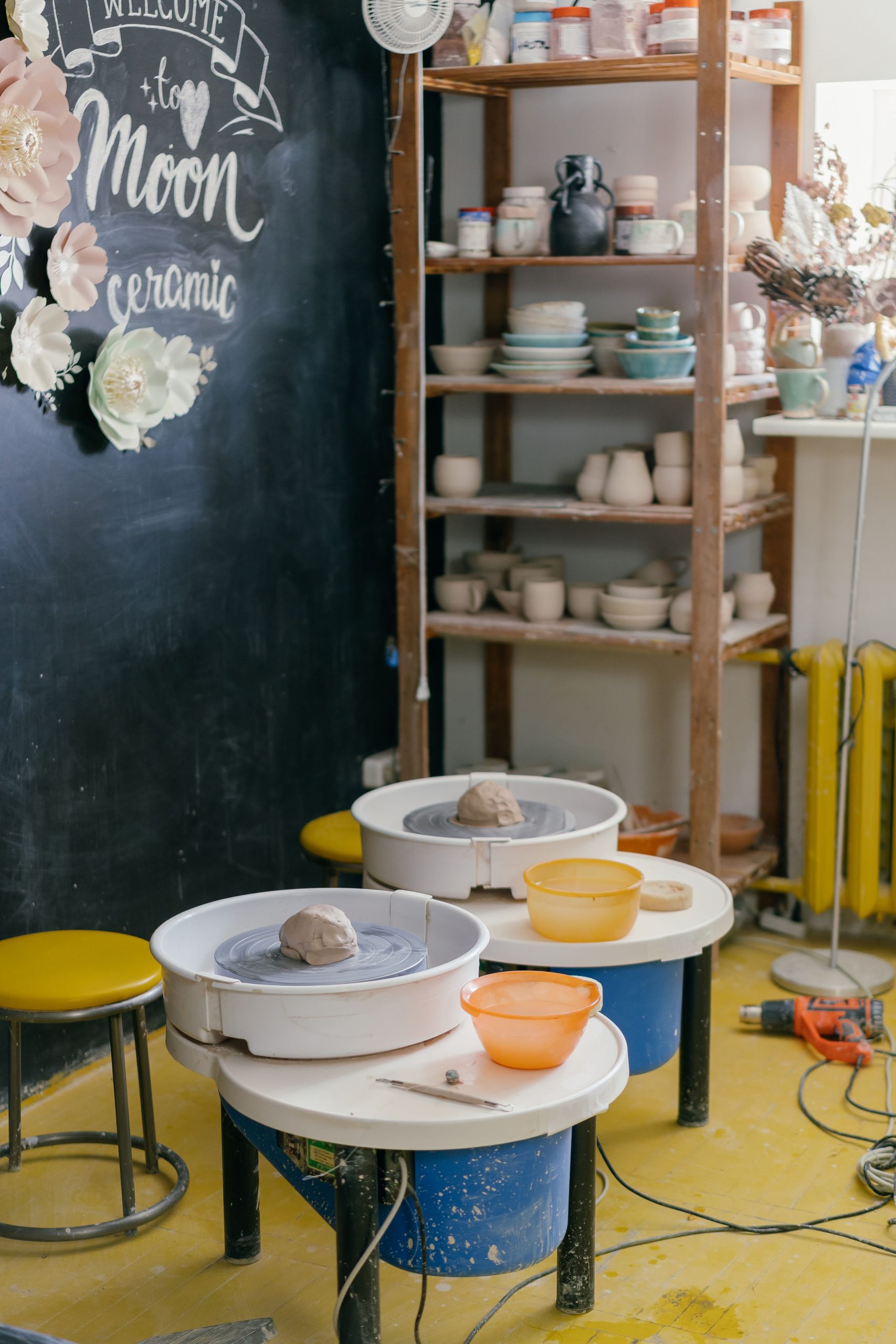 Inviting pottery studio featuring spinning wheels, tools, and handmade ceramics.