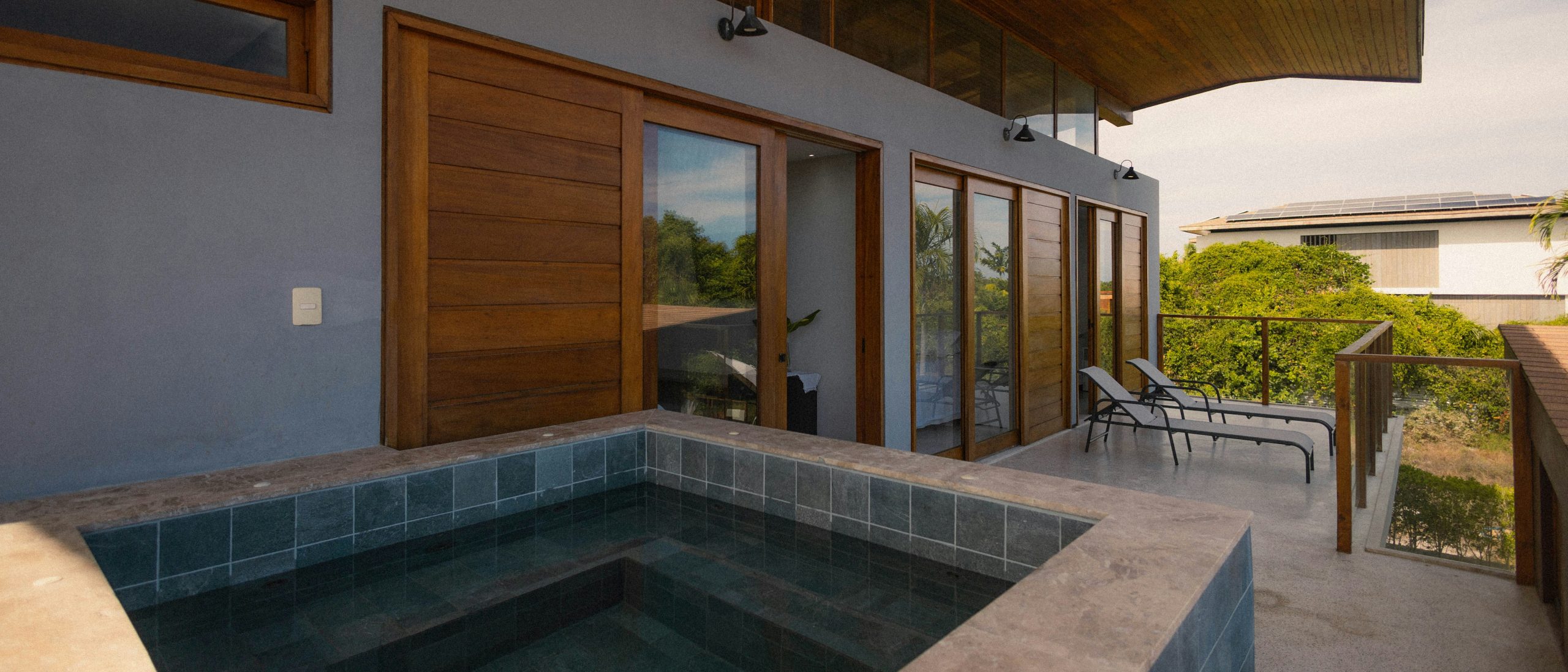 Jacuzzi on a balcony with lounge chairs and ocean view