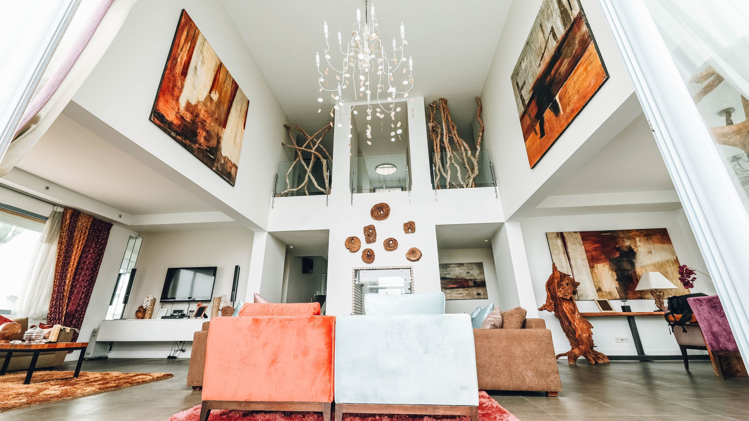 Luxurious interior with chandelier, art, and stylish furniture arrangement.