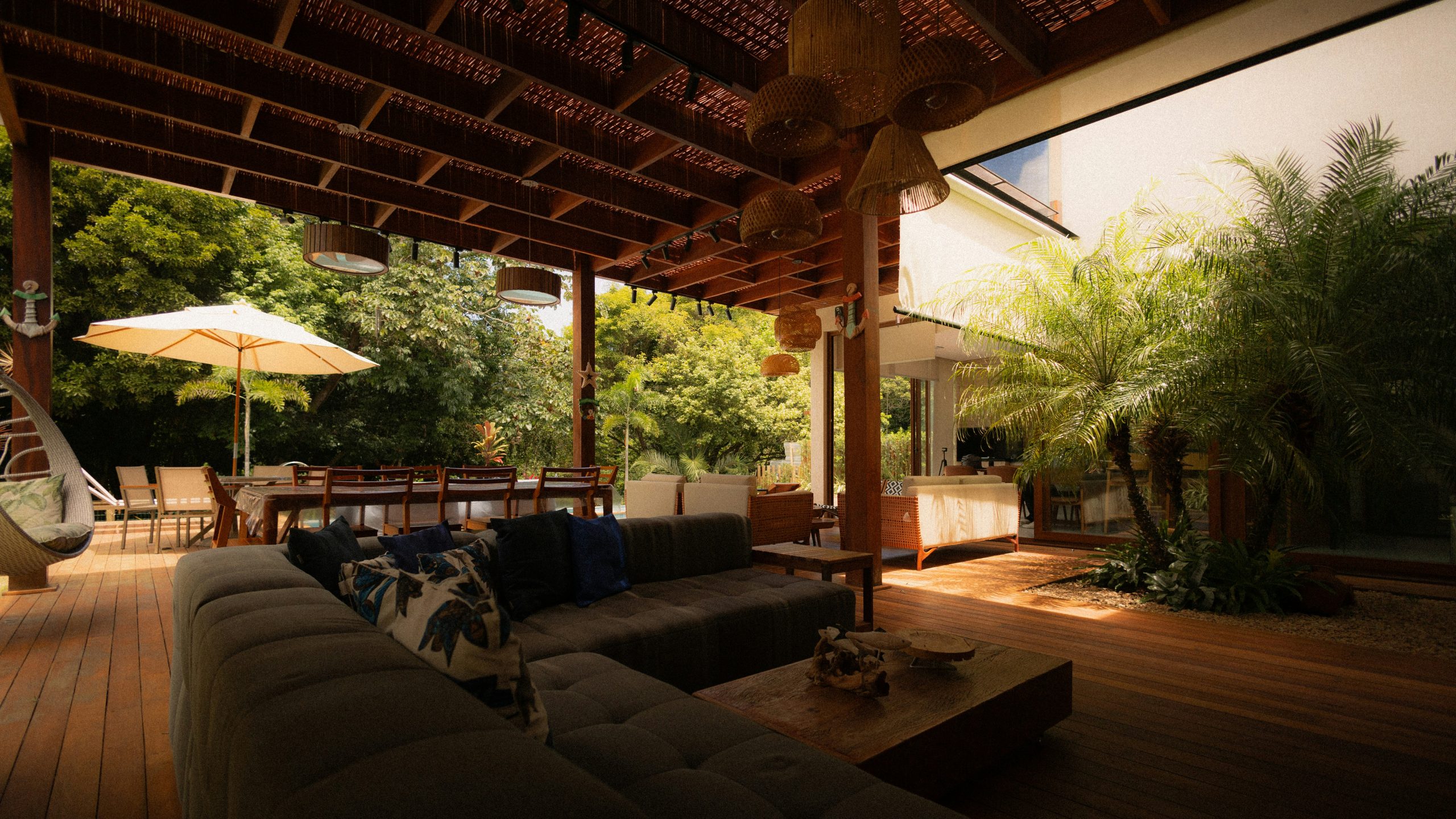 Luxurious outdoor living space with modern furniture and lush greenery.