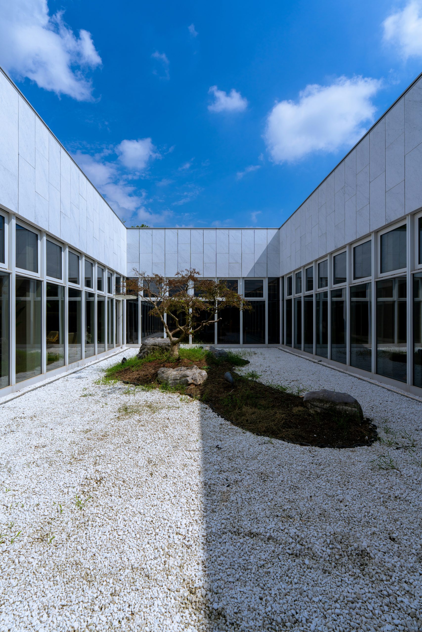 Modern courtyard with minimalist garden and blue sky