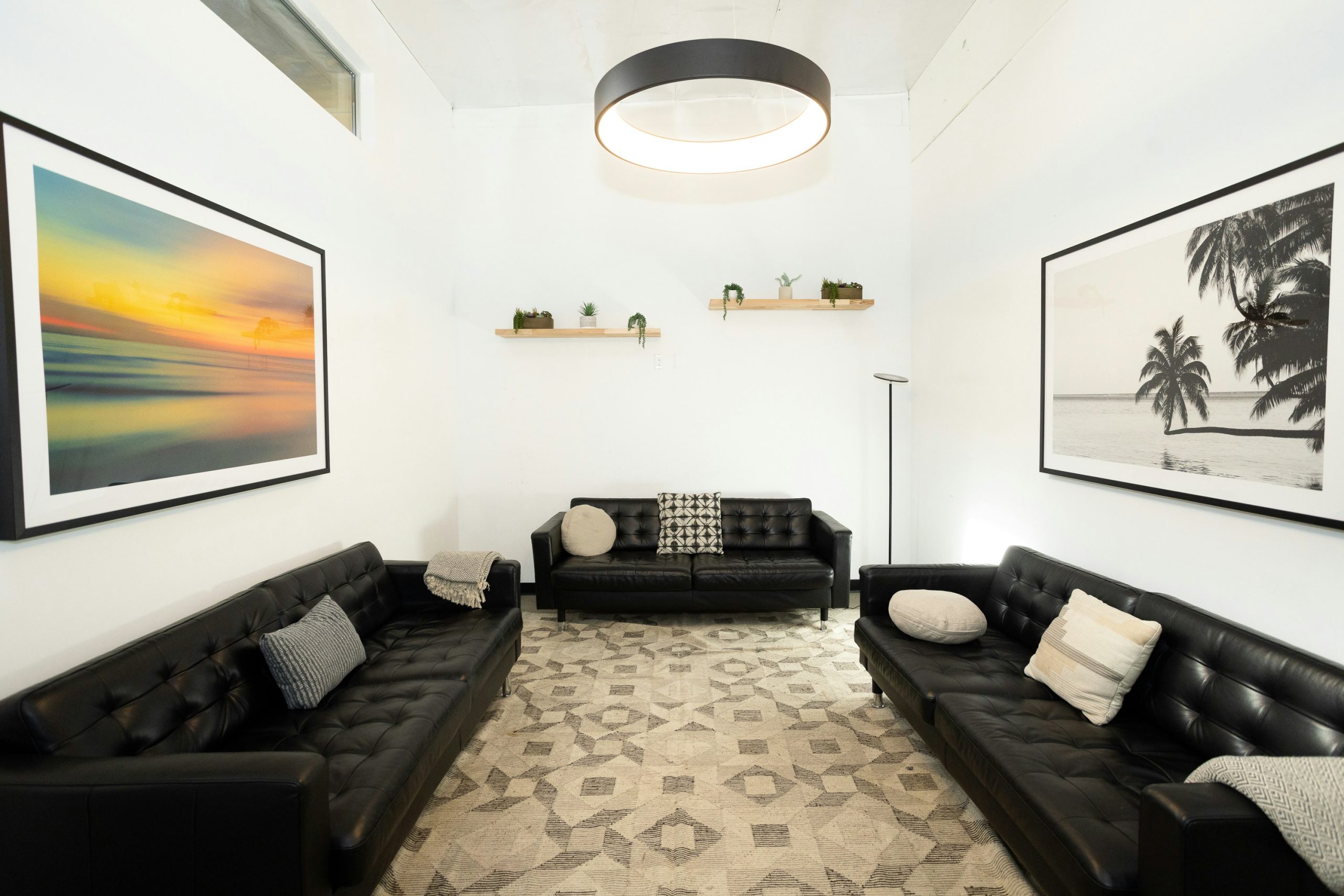 Modern living room with black sofas and art