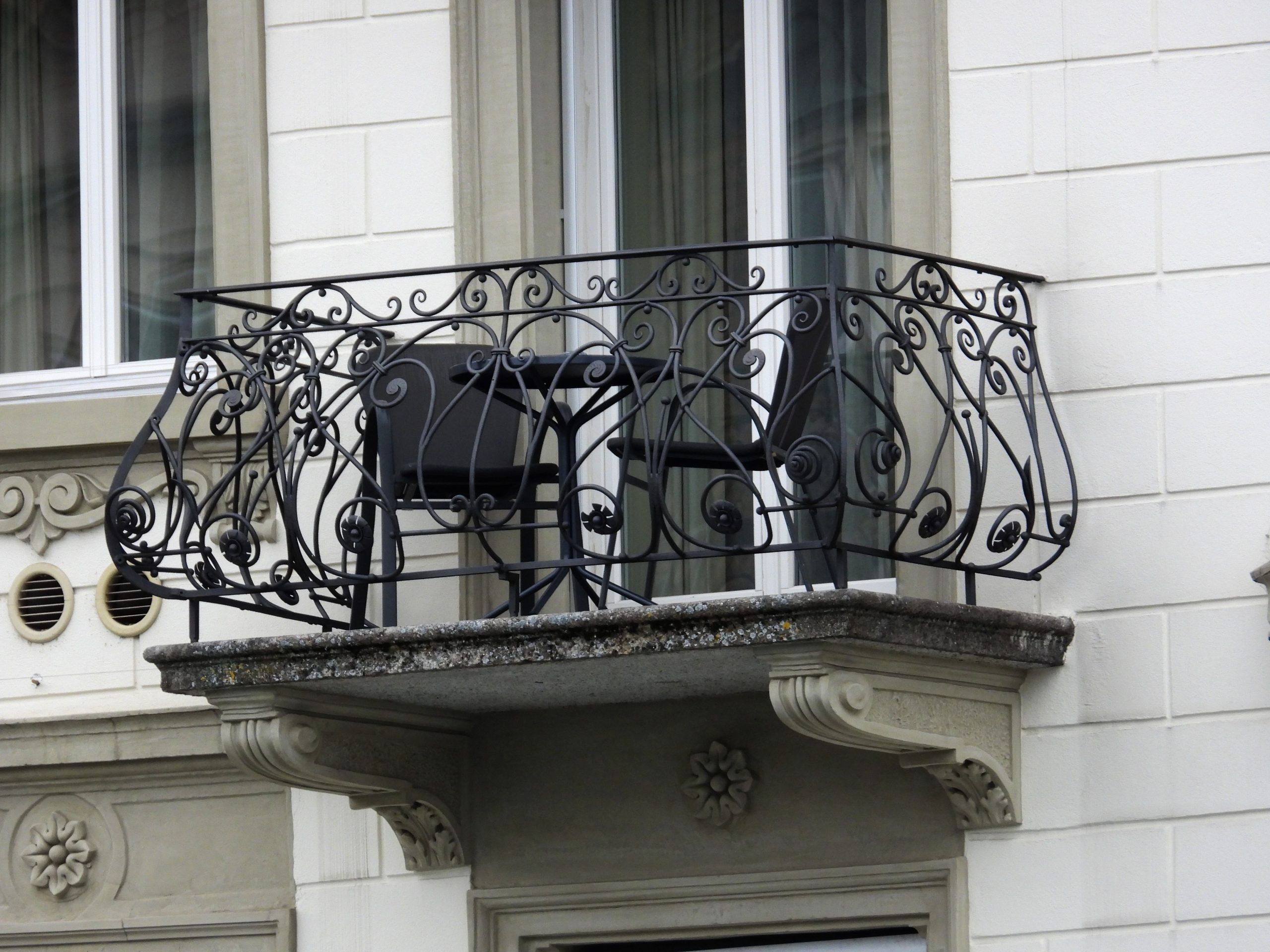 Picturesque urban balcony with intricate iron railing, perfect for a serene city escape.