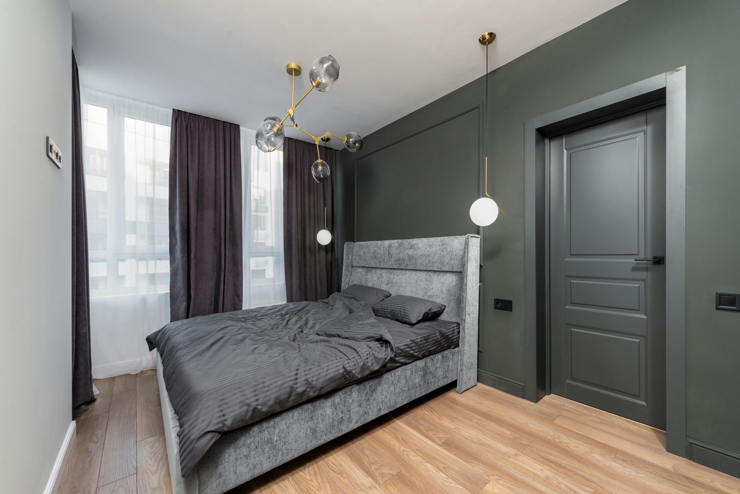 Sleek modern bedroom with elegant furnishings and dark color palette.