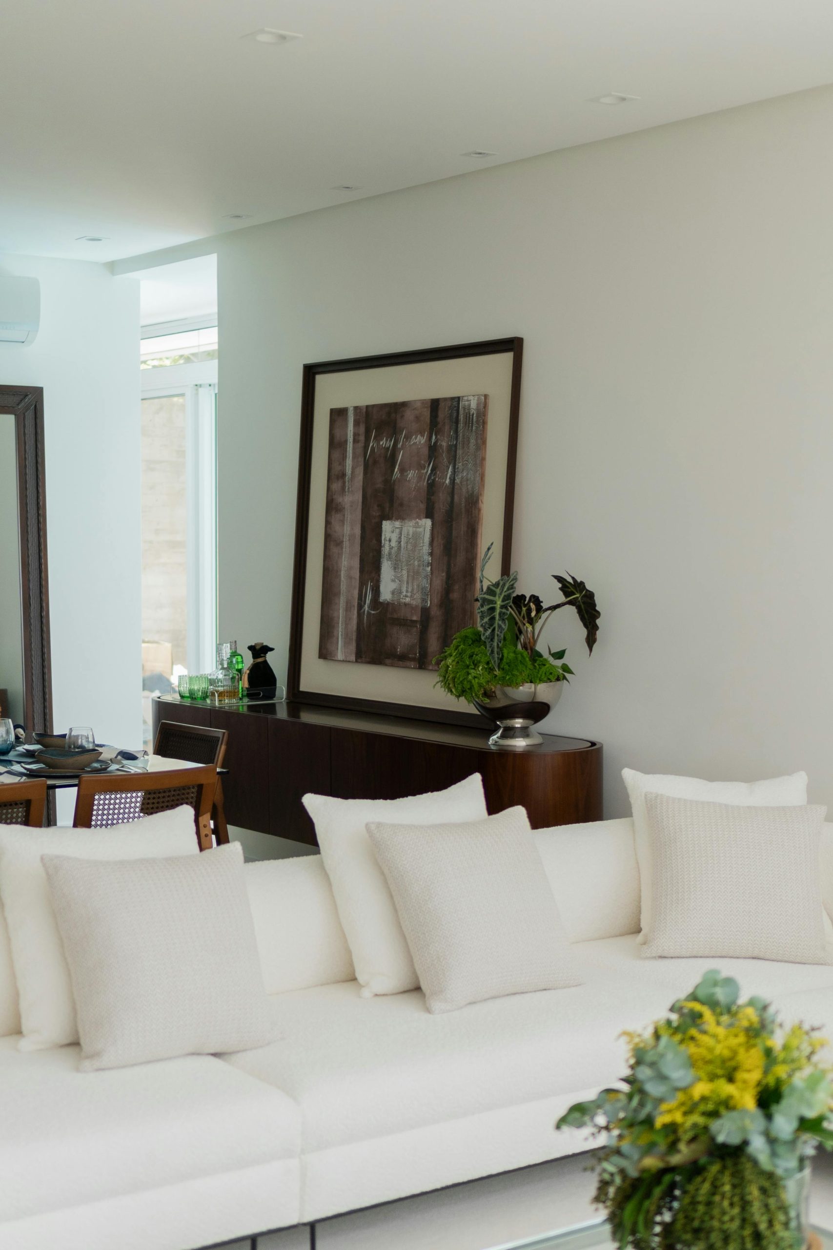 Spacious and stylish living room with white sofa and contemporary artwork on the wall.