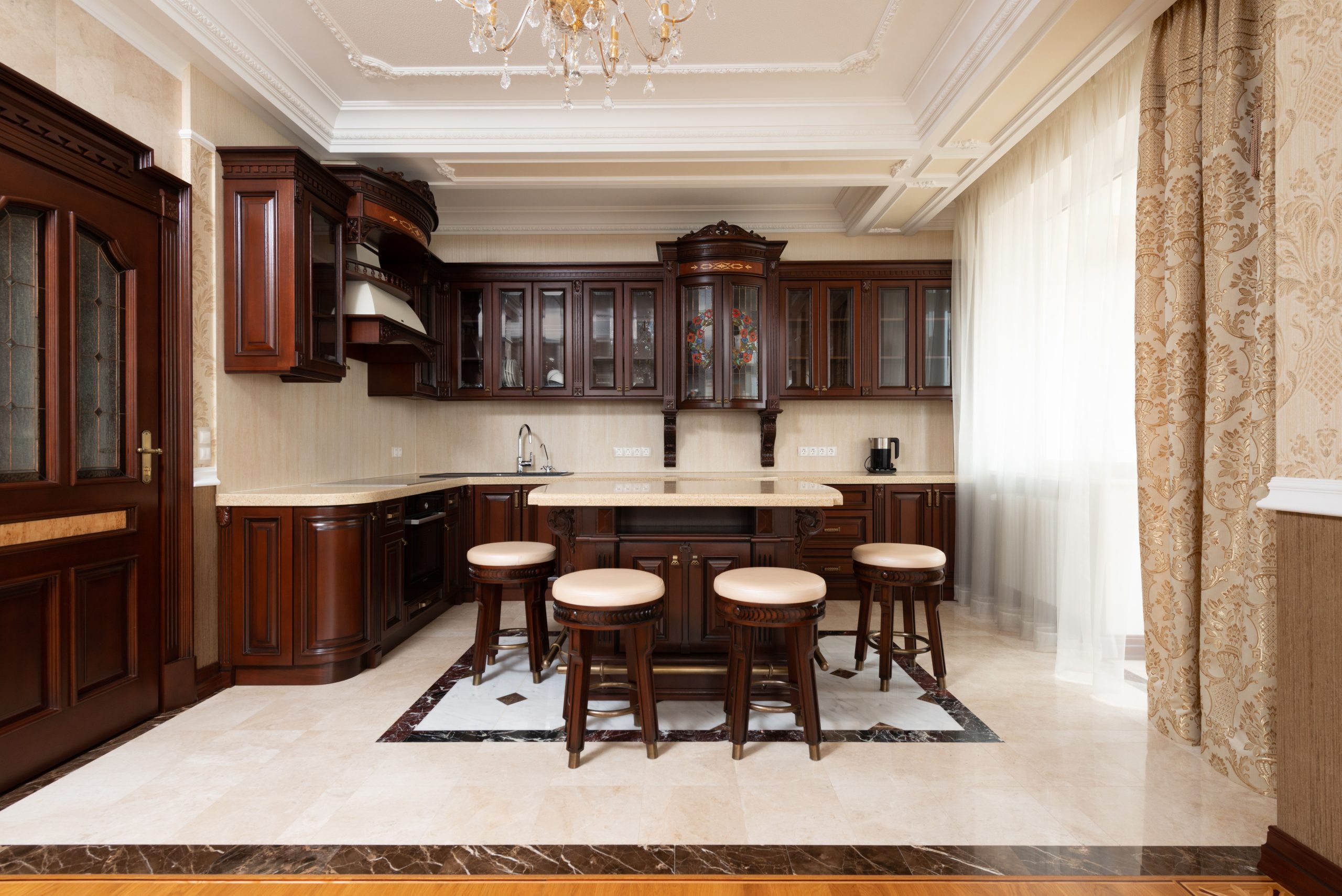 Spacious kitchen with dark wooden cabinetry and elegant decor, featuring a central island.