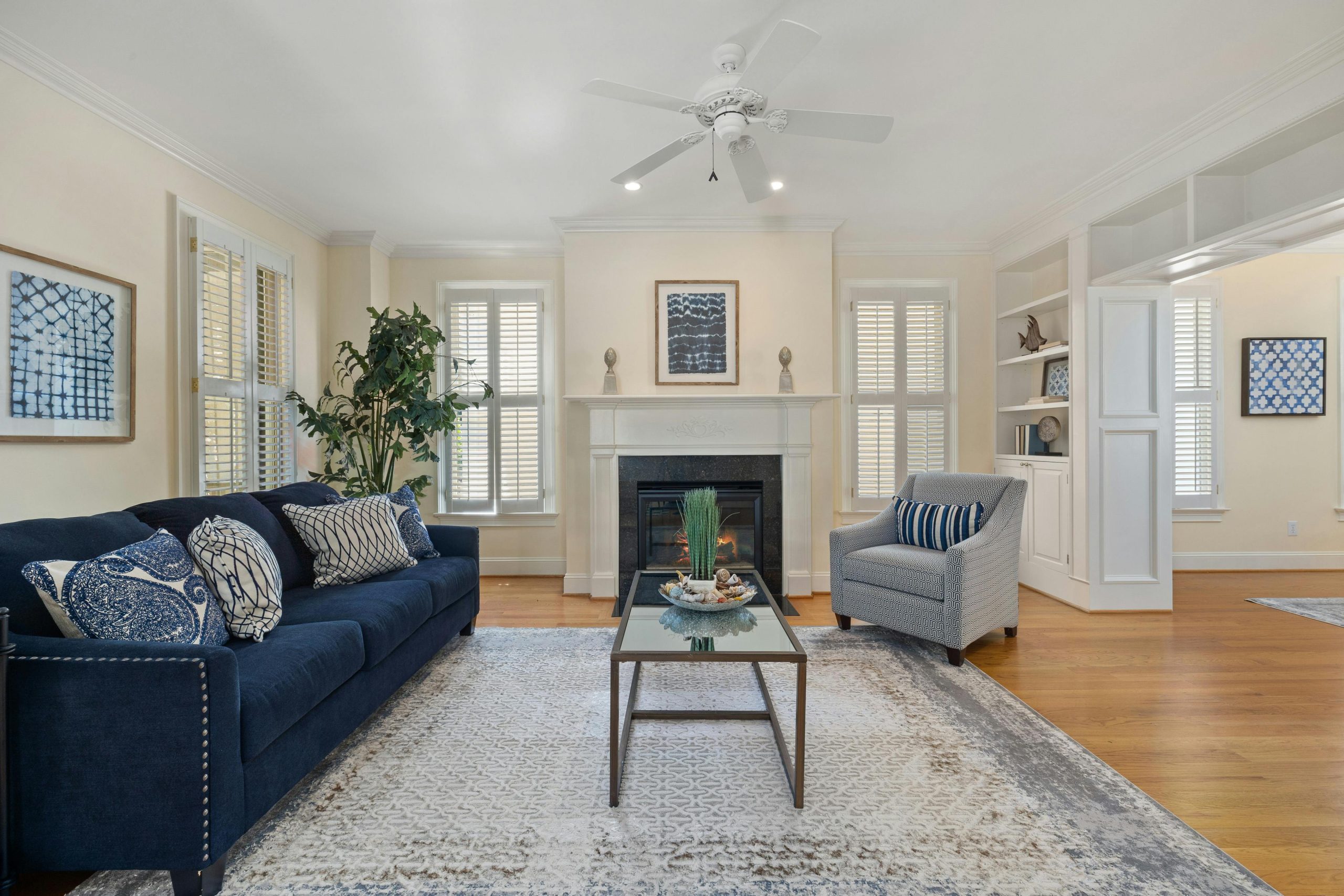Spacious living room featuring modern decor, a blue couch, and a cozy fireplace.