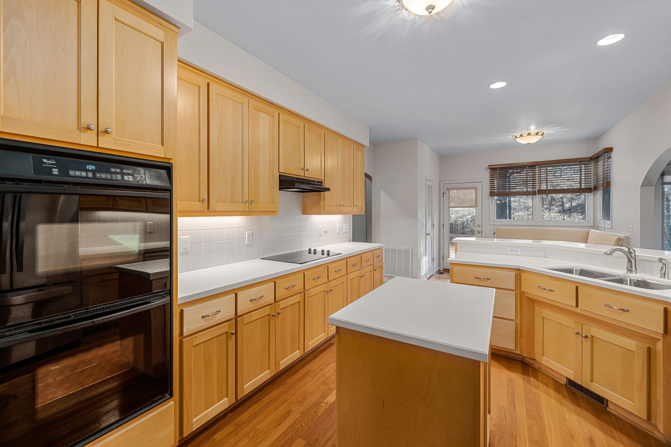 Spacious modern kitchen featuring wooden cabinets, kitchen island, and built-in appliances.
