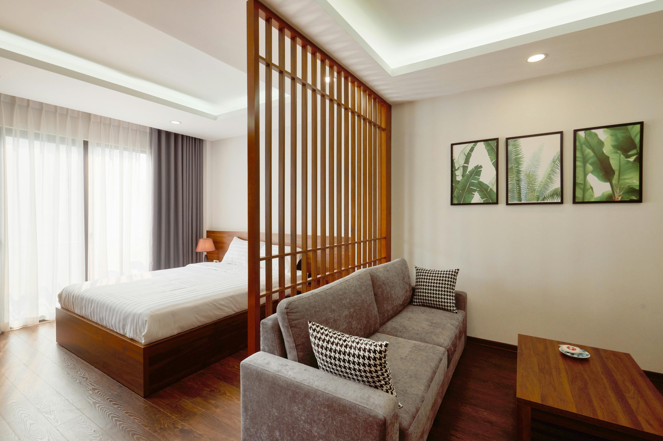 Stylish minimalist bedroom and living space with wooden elements and modern decor.