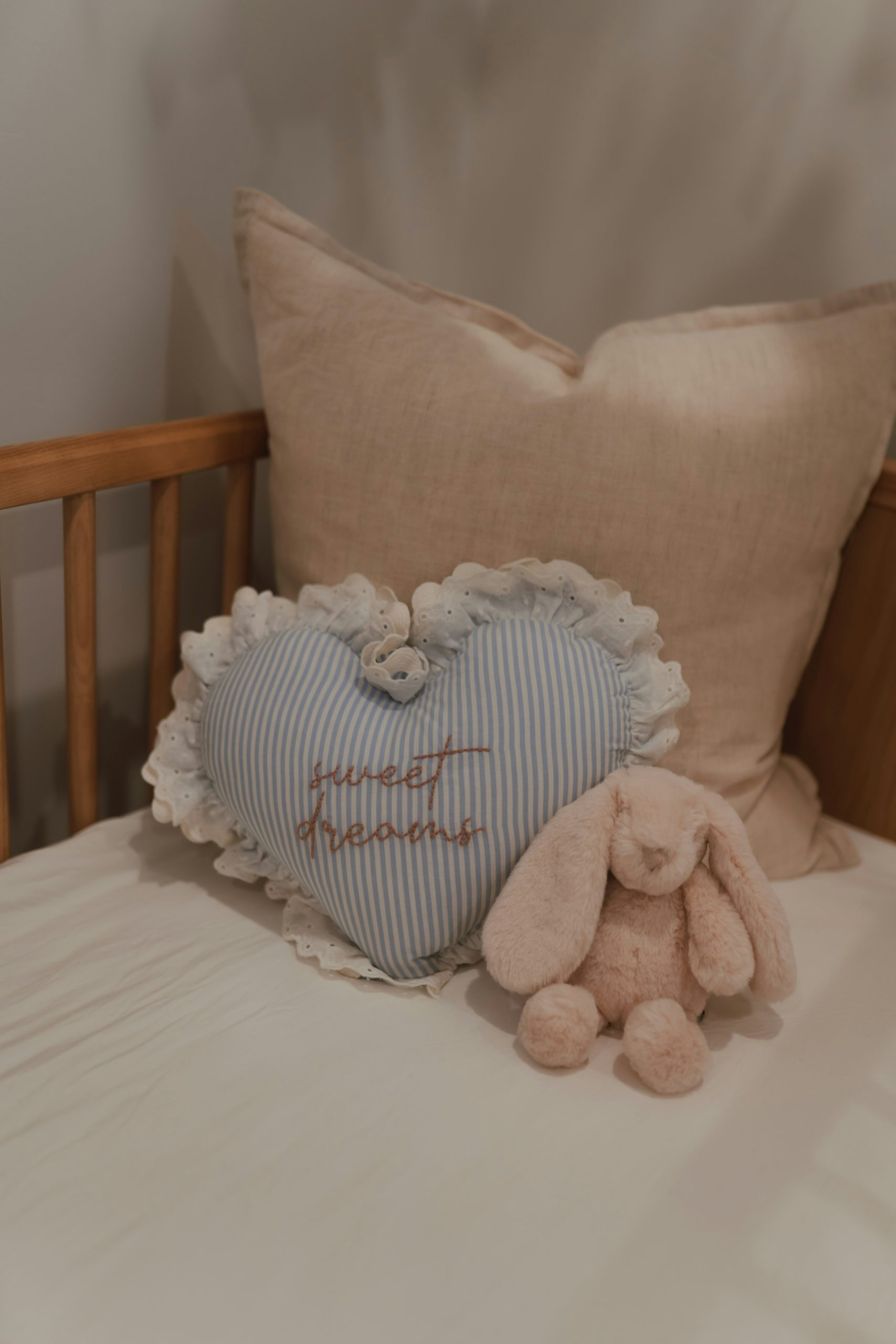 Sweet dreams heart pillow and plush bunny in a crib.