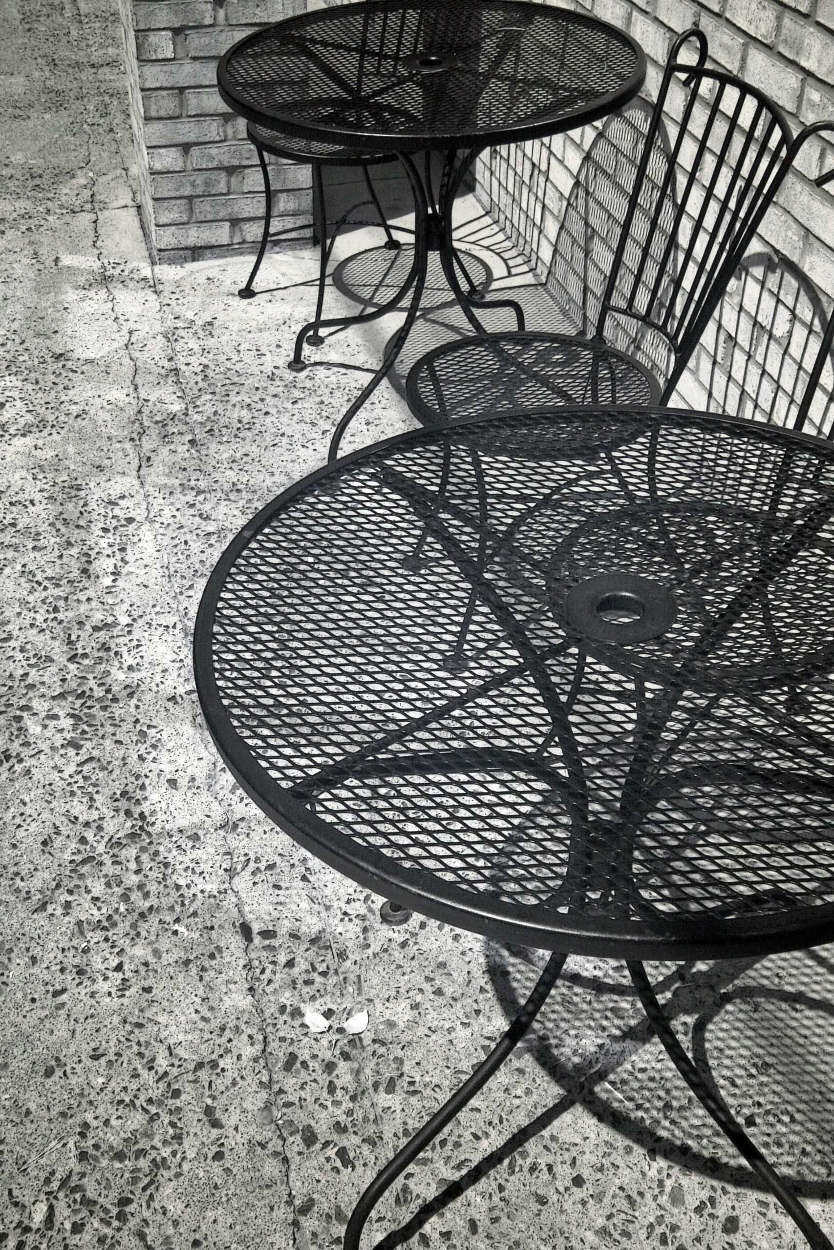 'Tables and Chairs' --- Tables and chairs and their shadows at an outdoor cafe in black and white.