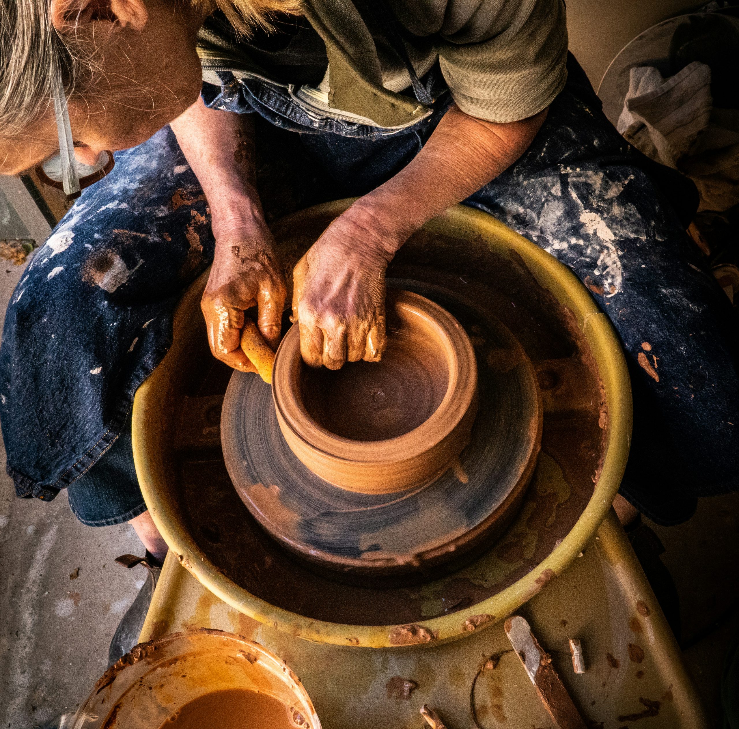Throwing a clay pot on a potter's wheel.