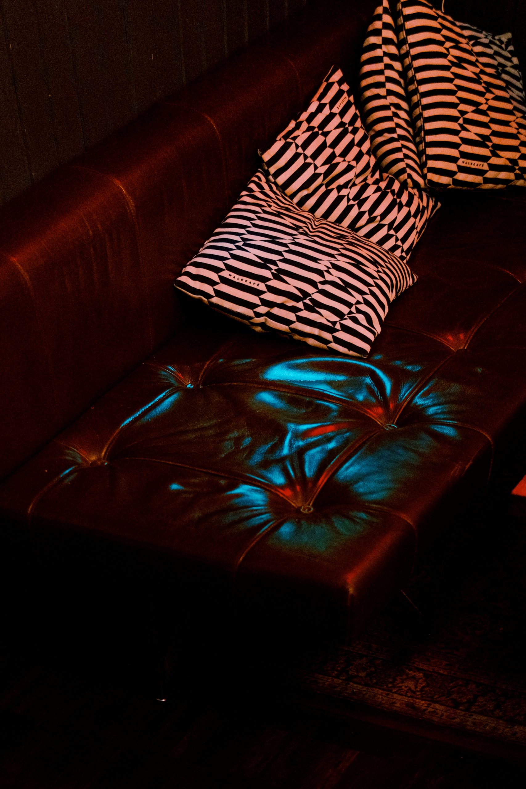 Tufted leather sofa with patterned pillows