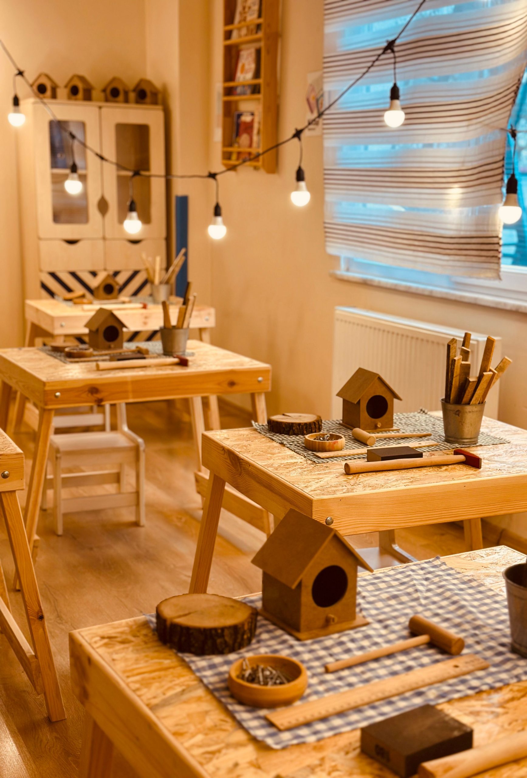 Warm indoor workshop setting with woodworking tools and birdhouse projects ready for crafting.