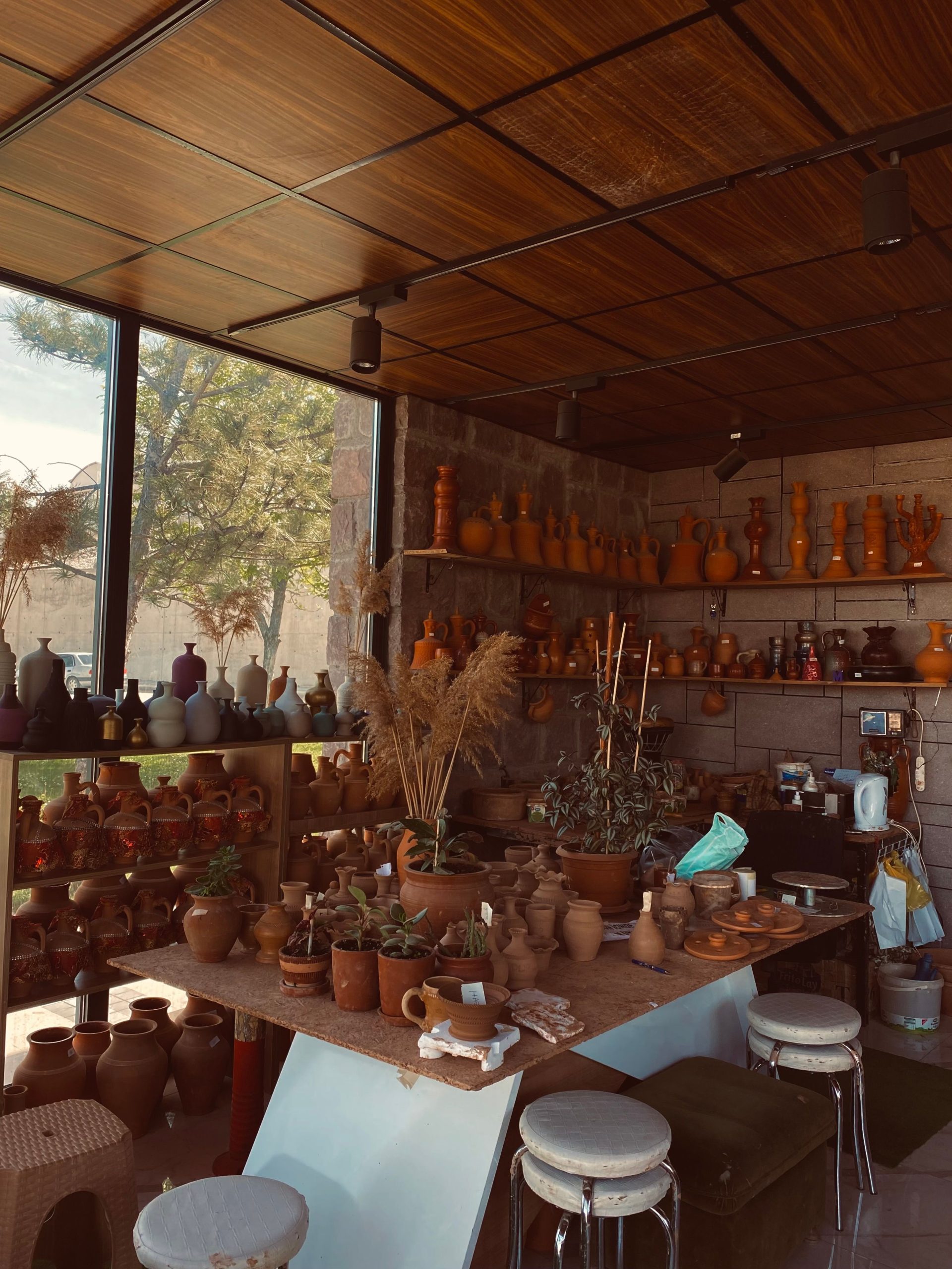 Warm, inviting pottery workshop filled with handmade clay pots and earthy decor.