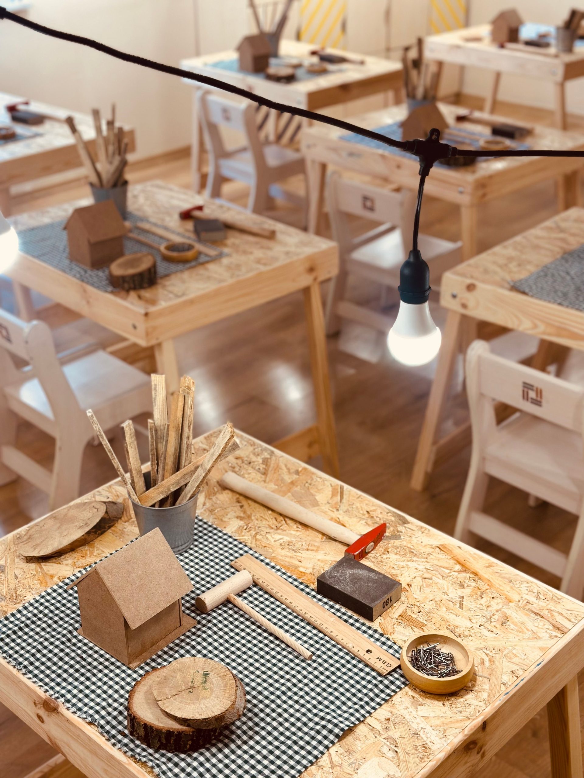 Wooden crafting station in a classroom with tools and supplies ready for use.
